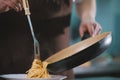 Chef serves spaghetti on the plate in restaurante