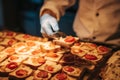 Chef is serving canapes toasted bread with cheese and tomato in a restaurant.