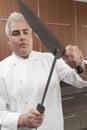 Chef Sharpening Knives In Commercial Kitchen