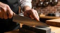 Chef sharpens kitchen knife on whetstone in professional kitchen preparing for culinary task Royalty Free Stock Photo