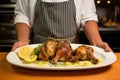 chef showing plate of garlic butter basted chicken legs