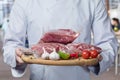Chef shows the vacuumized meat for sous vide cooking on a blurred background