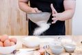 Chef sifts flour through a sieve on wooden table,Flour sifting through a sieve for a baking,Baking concept Royalty Free Stock Photo