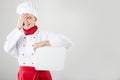 Chef Sign. Woman cook / baker looking over paper sign billboard. Surprised and funny expression woman isolated on white background