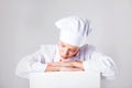 Chef Sign. Woman cook / baker looking over paper sign billboard. Surprised and funny expression woman on white background Royalty Free Stock Photo