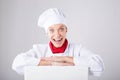 Chef Sign. Woman cook / baker looking over paper sign billboard. Surprised and funny expression woman on white background Royalty Free Stock Photo