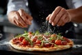 Chef prepares pizza with fresh ingredients in a modern kitchen during a lunch rush time Royalty Free Stock Photo