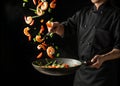 Chef skillfully tosses shrimp and vegetables in a wok during a cooking demonstration in a professional kitchen setting Royalty Free Stock Photo