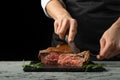 Chef, sliced with meat steak on a black background, Recipe concept for homemade food. A larger plan