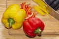 Chef slices paprika peppers on vegetarian dietary dish. in gloves on a wooden cutting board