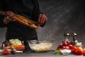 Chef slices potatoes and sprinkles in water, freezing in motion. Against the background of vegetables and ingredients. With space