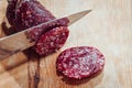 Chef slices salami on a wooden board Royalty Free Stock Photo