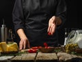 The chef slices tomatoes on a cutting board for Italian focaccia bread. Selected fresh ingredients. Cooking process. Country style Royalty Free Stock Photo