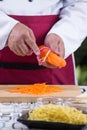 Chef slicing carrots with peeler Royalty Free Stock Photo