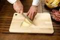 Chef slicing cheese, hands detail