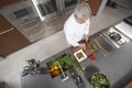 Chef Slicing Cucumber On Board At Commercial Kitchen Counter