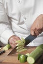 Chef Slicing Cucumber On Chopping Board