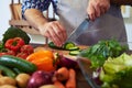 Chef slicing cucumber with a knife on chopping board Royalty Free Stock Photo