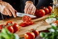 Chef slicing fresh tomato for a salad Royalty Free Stock Photo