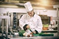 Chef slicing tomatoes in professional kitchen