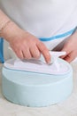 Chef smoothes mastic on the cake Royalty Free Stock Photo