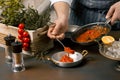 Chef spreading tomato sauce from frying pan. Gourmet Restaurant