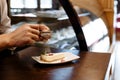 Chef sprinkled with powdered sugar sieve of a piece of cake on a plate on a wooden table Royalty Free Stock Photo