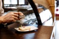 Chef sprinkled with powdered sugar sieve of a piece of cake on a plate on a wooden table Royalty Free Stock Photo