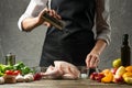 The chef sprinkles salt and chicken with fruit for baking for a holiday, Christmas, New Year, Benefit Day. Background for the menu