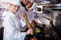 Chef sprinkling pepper on tomatoes