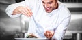 Chef sprinkling spices on dish Royalty Free Stock Photo