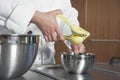 Chef Squeezing Lemon At Counter In Commercial Kitchen