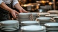 Chef stacking clean plates in a professional kitchen setting Royalty Free Stock Photo