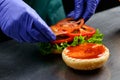 Chef in sterile gloves prepares a vegetarian burger