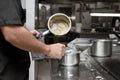 Chef stirring sauce in stainless steel pot, close-up. Professional kitchen, restaurant.