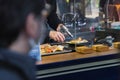 A chef at a street kitchen in Tokyo preparing seafood using a Bunsen burner