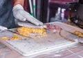 Chef at a street market preparing sandwich with grilled melted cheese and bacon Royalty Free Stock Photo