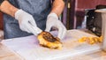 Chef at a street market preparing sandwich with grilled melted cheese and bacon Royalty Free Stock Photo