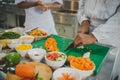 Chef student chopping fresh vegetables with knife during culinary training in professional kitchen Royalty Free Stock Photo