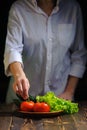 Chef on the table plate with vegetables for salad