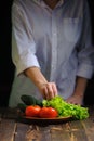 Chef on the table plate with vegetables for salad