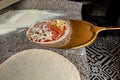 Chef taking raw pizza on metal shovel for baking in the oven. Traditional way baked wood fired oven in traditional restaurant Royalty Free Stock Photo