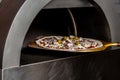Chef taking raw pizza on metal shovel. Restaurant chef takes pizza from oven in traditional restaurant. Preparing traditional Royalty Free Stock Photo