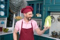 Chef talks to vegetables. Very happy man holding fresh chinese cabbage. Cook with big smile and pakchoi in hand.