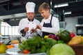 Chef teacher teaches cooking to the group children in class kitchen room