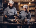 Chef teaching his assistant to bake the bread in the bakery.