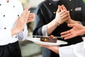 Chef team in restaurant kitchen with dessert Royalty Free Stock Photo