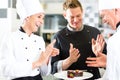 Chef team in restaurant kitchen with dessert Royalty Free Stock Photo