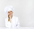 Chef thinking looking smiling and happy to the side. Woman chef, cook or baker in chef uniform and hat. Royalty Free Stock Photo