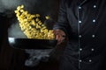 The chef throws food into a hot, steamy frying pan. Thai street food shell type pasta. Advertising space on a black background Royalty Free Stock Photo